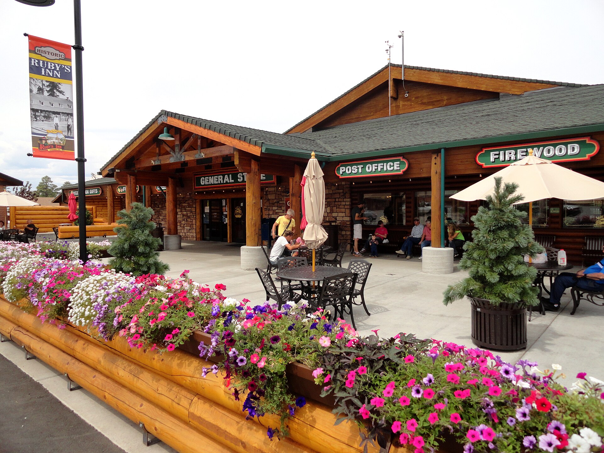 A flower-lined patio outside the Ruby's Inn General Store and Post Office with a Historic Ruby's Inn banner